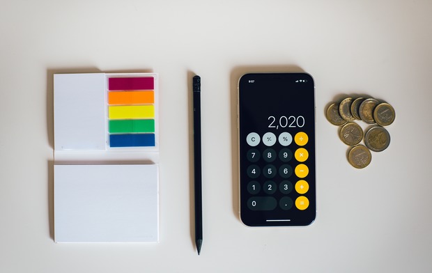 Sticky notes, a pen, a phone with a calculator app and loose change